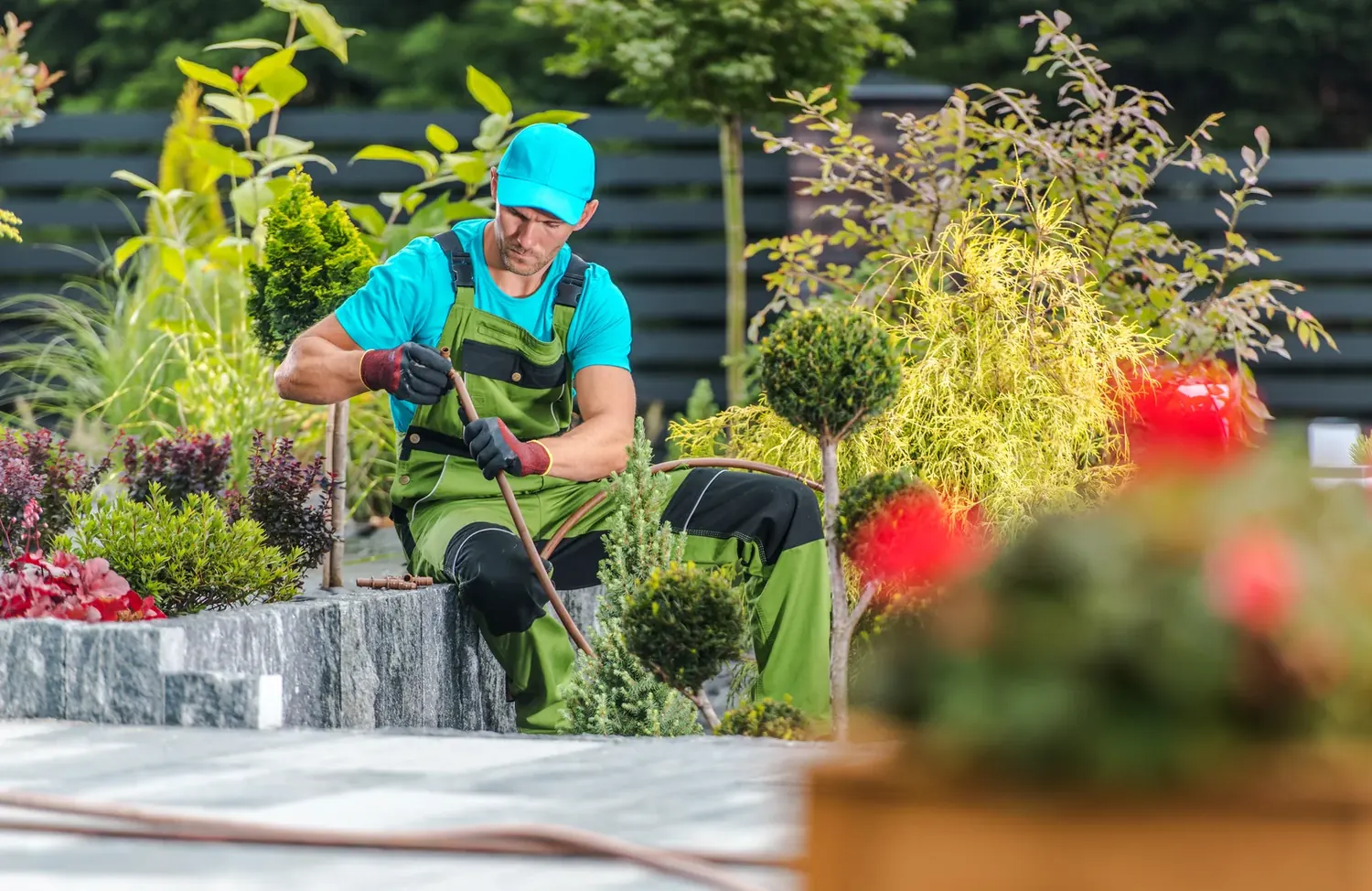 Landscaper connecting irrigation tubing in a green garden