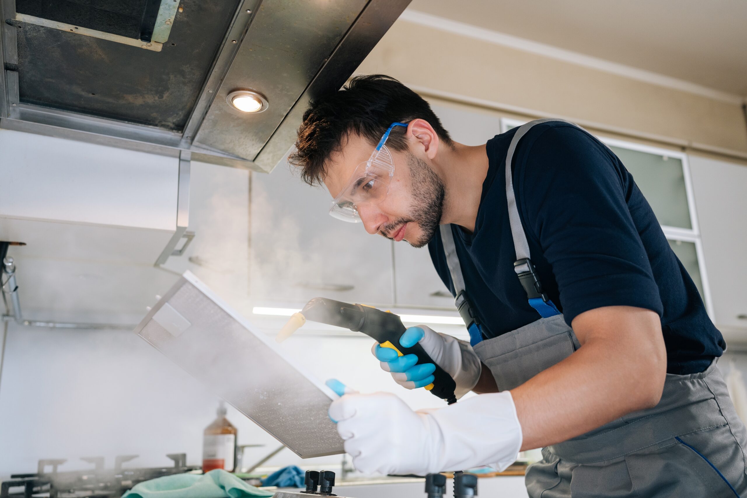 Professional worker cleaning kitchen filter